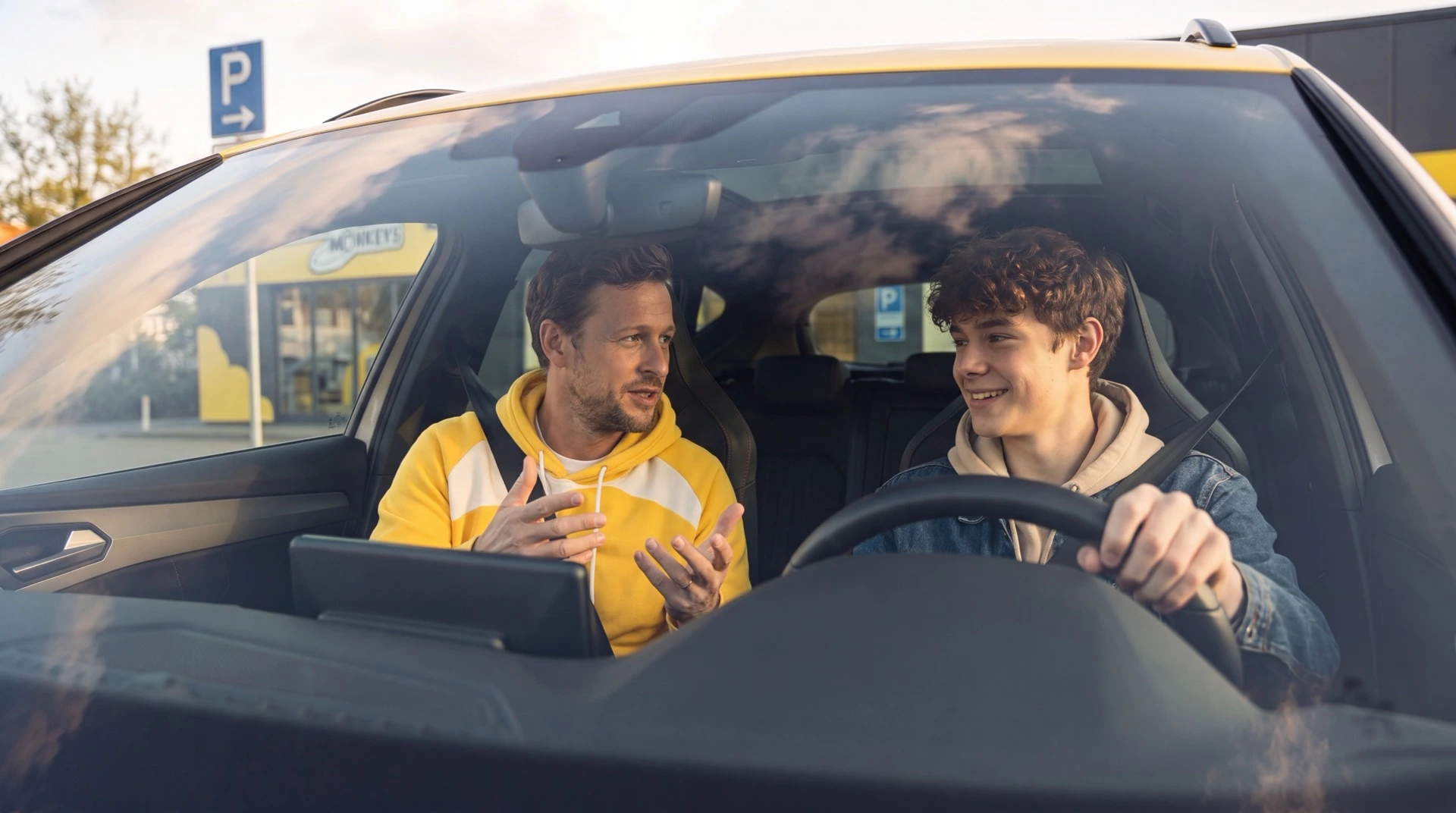 Fahrlehrer spricht mit Fahrschülerin während der Fahrstunde